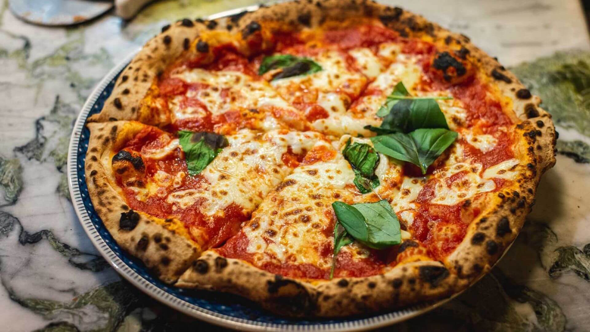 napolitansk pizza er laget med bare noen få ingredienser, inkludert San Marzano-tomat, fersk mozzarella ost og ferske urter som basilikum