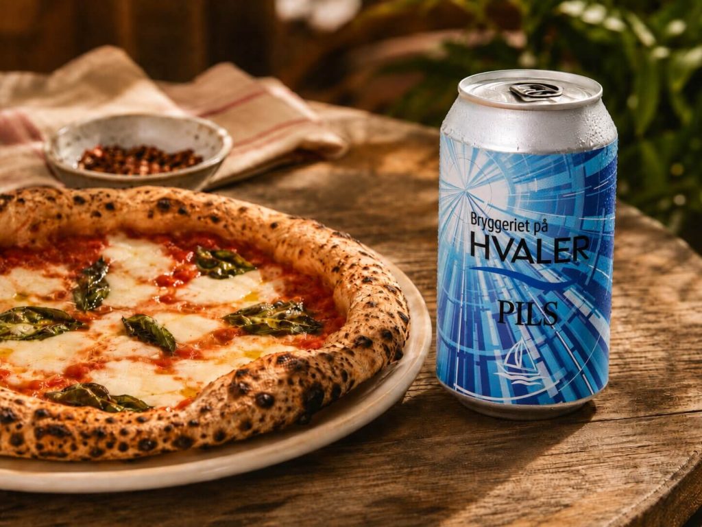 Hvaler Pils på boks ved siden av napolitansk pizza med mozzarella, tomatsaus og basilikum.